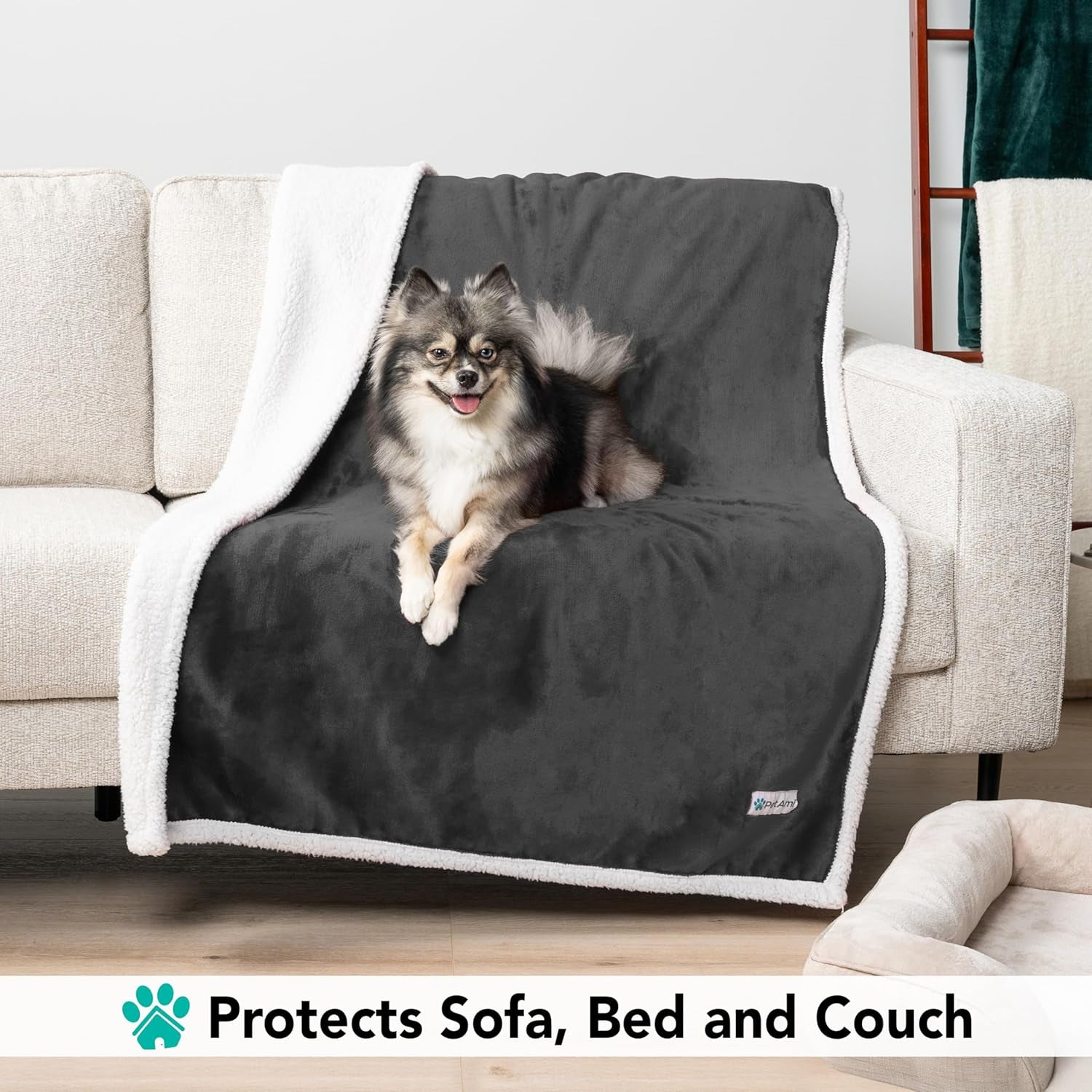 Small dog sitting on gray reversible sherpa dog blanket covering couch to protect sofa and furniture from pet hair and dirt
