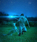 Person playing fetch with a dog using a glow in the dark dog ball in a starry night setting.
