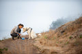 A person using a collapsible dog bowl for travel with their dog on a scenic trail.